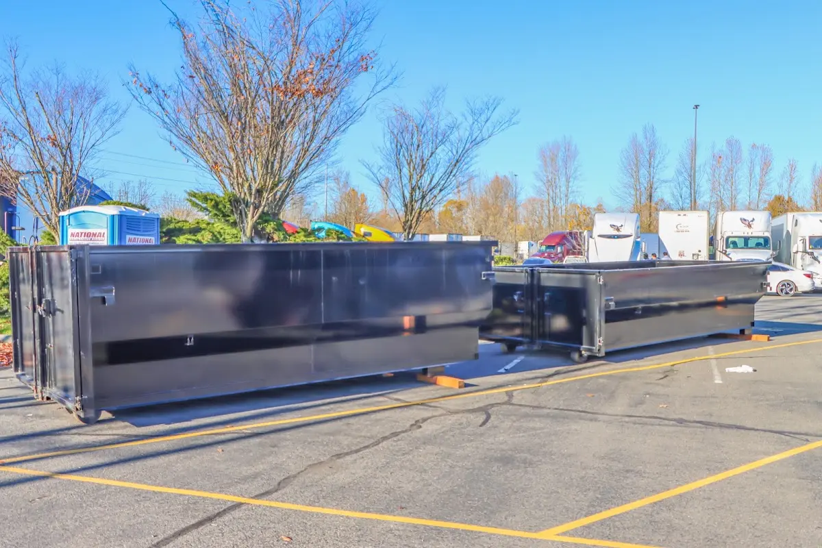 Professional dumpster rental service with roll-off container on residential driveway in Hayward